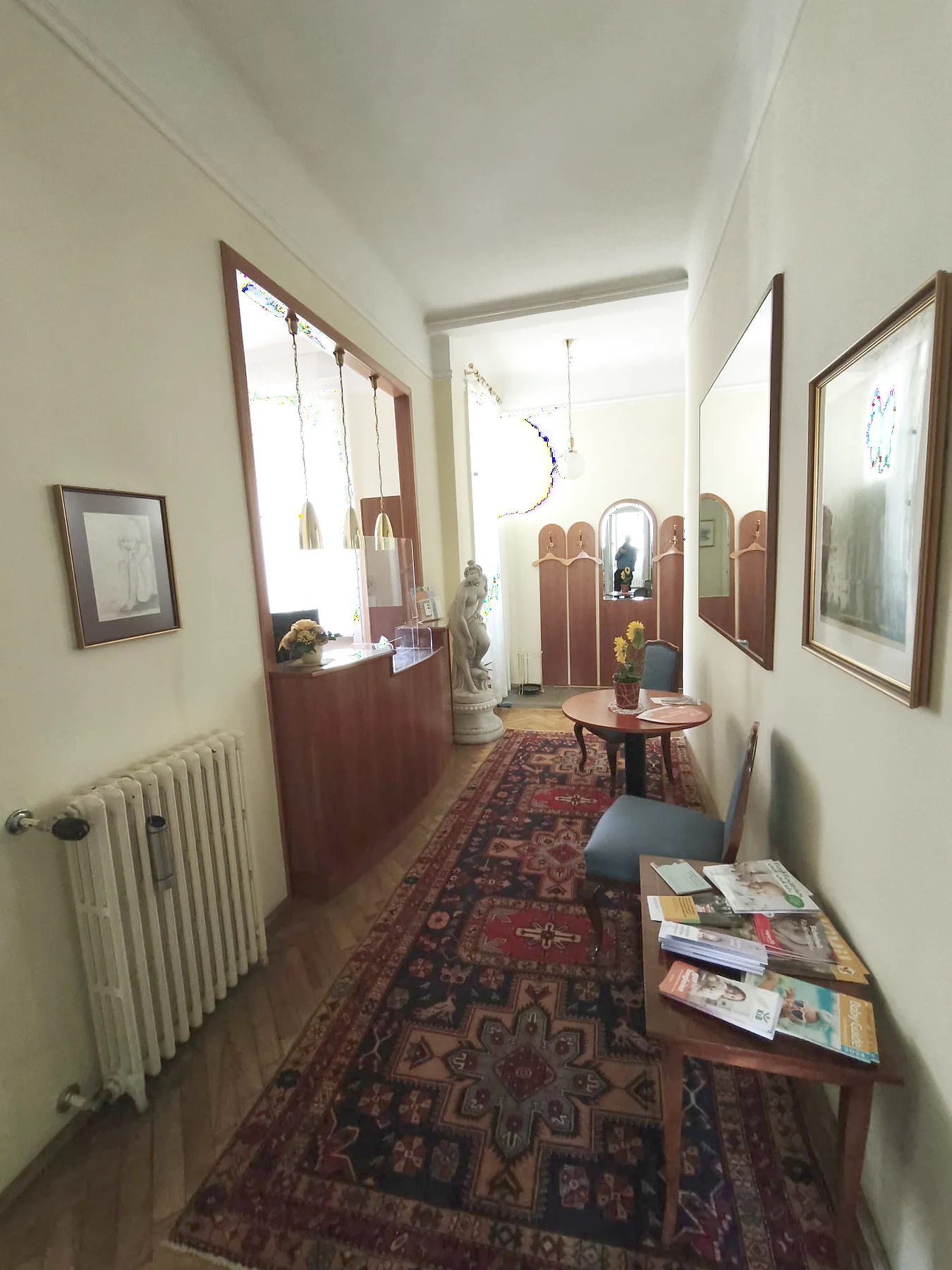 Flur der Ordination Dr. Fischl mit Teppich, Sitzplatz und Zeitschriften